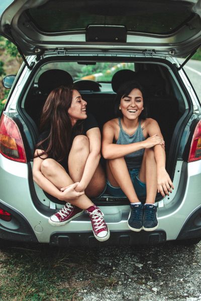 Friends talking & laughing in car rear
